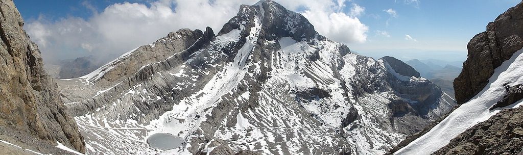 Cumbre nevada del Monte Perdido y un pequeño lago helado vistos desde el Cilindro
