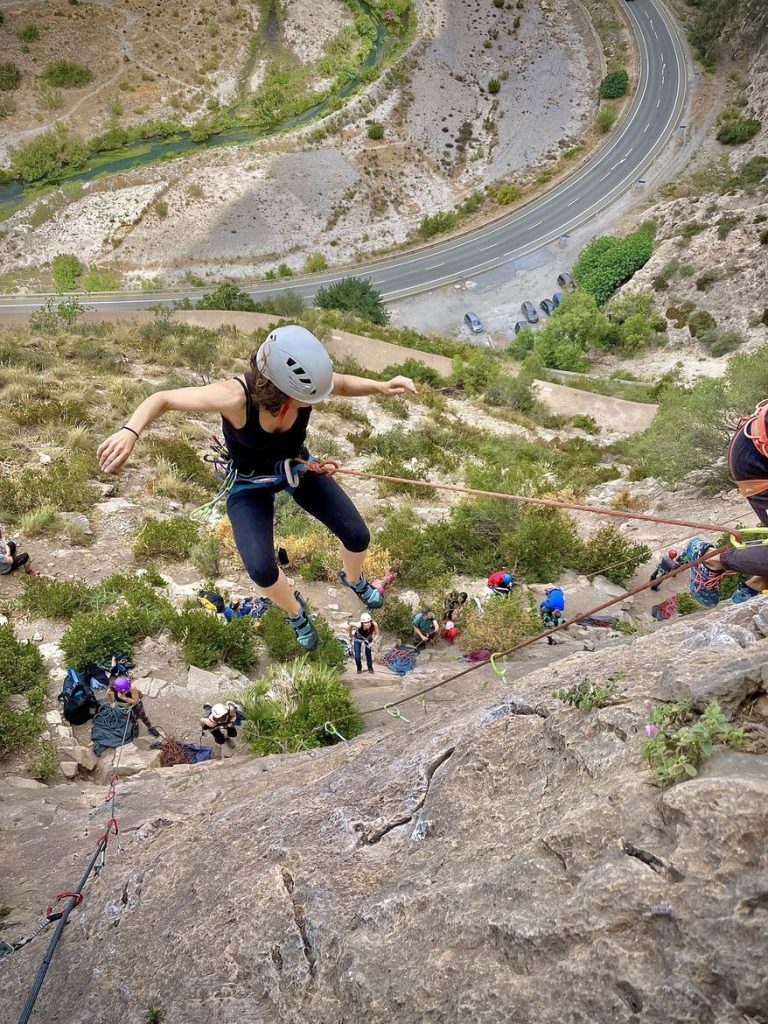 Escaladora en una caída controlada sobre una pared de roca durante un curso de aseguramiento en Granada